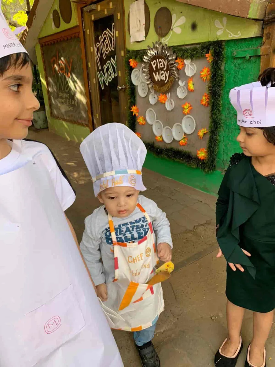 Toddler in a chef apron and hat