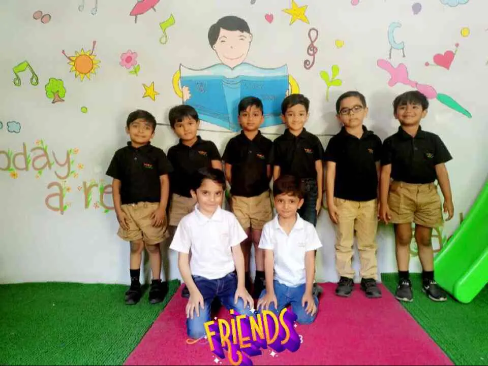Group of school friends posing in front of a painted wall