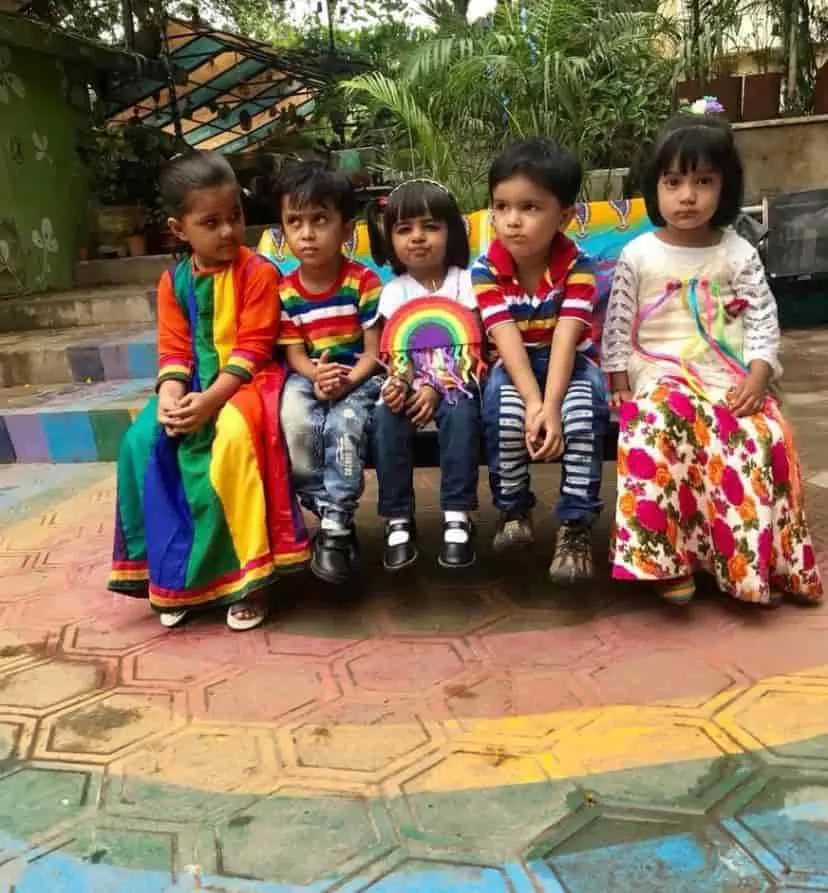 Children in rainbow colours sitting together