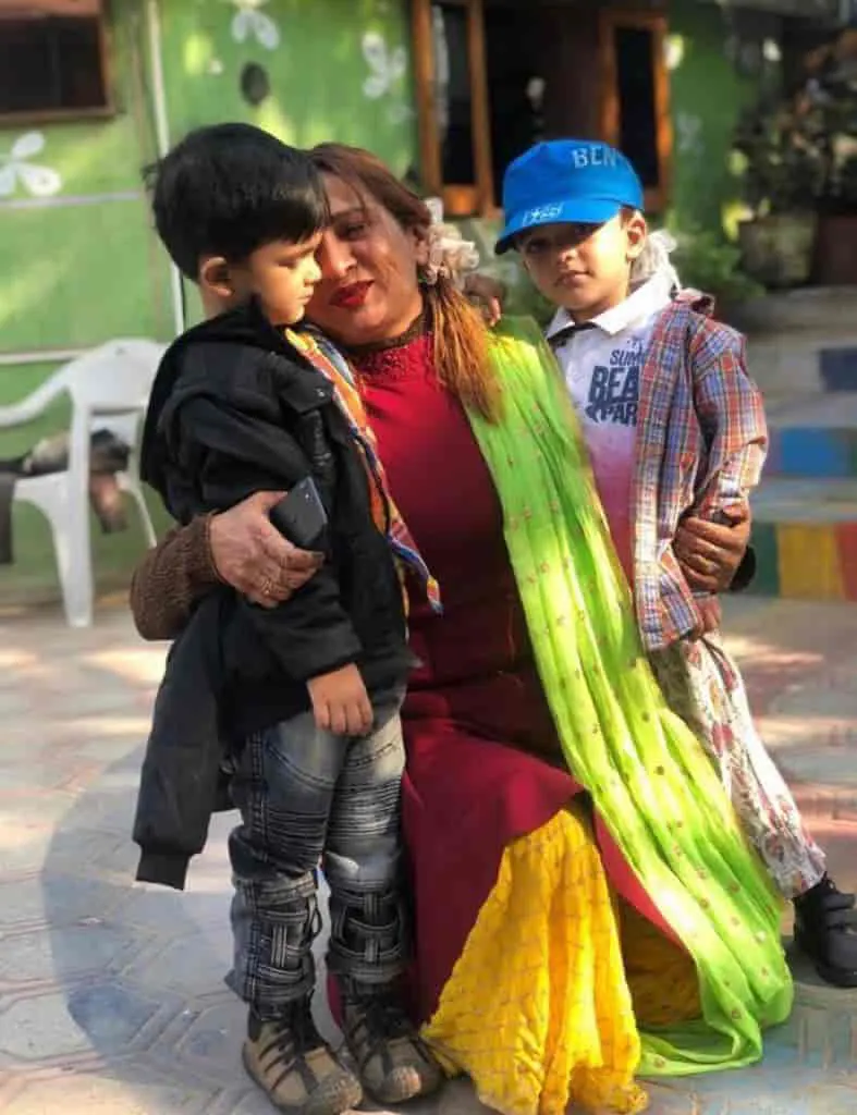 Teacher hugging two Playway children in costume
