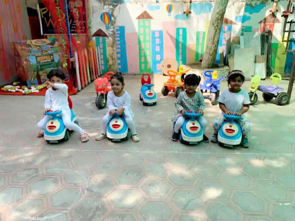 Children on ride-on toy cars in the play court