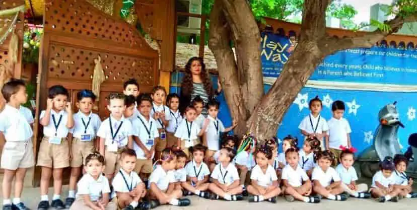 Children in school uniform sitting under the tree